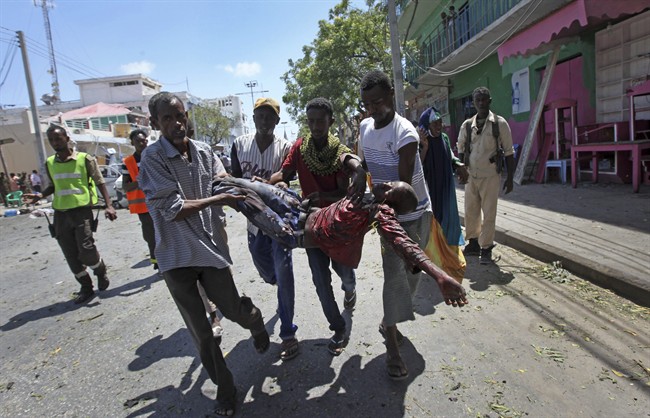 Rescuers carry away a man who was wounded in a car bomb attack in Mogadishu, Somalia Monday, March 13, 2017. A suicide car bomber detonated near the Weheliye hotel in the capital Monday morning, killing a number of people on the busy Maka Almukarramah road, police said. (AP Photo/Farah Abdi Warsameh).