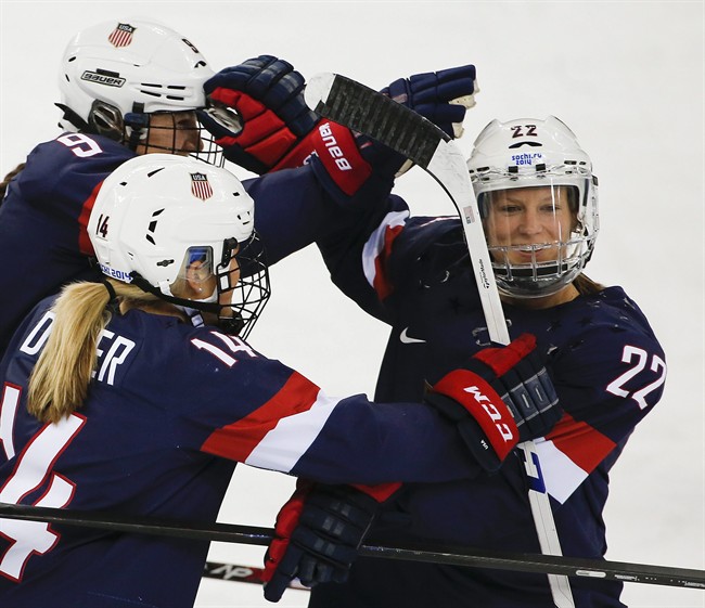 In this Feb. 17, 2014, file photo, Kacey Bellamy of the United States, right, is congratulated by teammates after scoring a goal against Sweden during the first period of the 2014 Winter Olympics women's semifinal ice hockey game in Sochi, Russia.