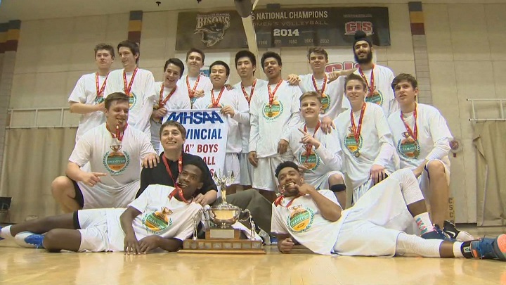 The Oak Park Raiders pose with their championship trophy and banner after winning the provincial basketball final.