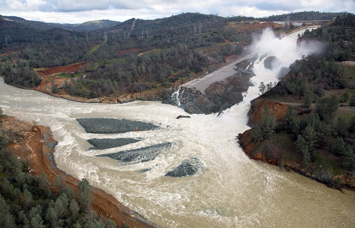 An aerial view of the damaged Oroville Dam spillway is shown as water output is gradually reduced from the damaged spillway. (Dale Kolke / California Department of Water Resources/Handout)