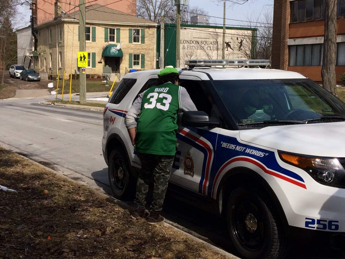 A man speaks with police after partiers at a frat house on Ridout St. were asked to dismantle a tent.
