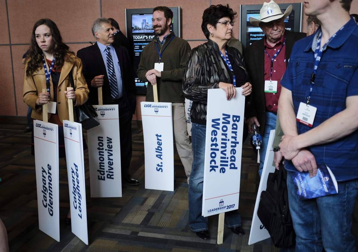 Delegates hold riding signs at the Alberta PC Party leadership convention in Calgary, Alta., Friday, March 17, 2017. THE CANADIAN PRESS/Jeff McIntosh.