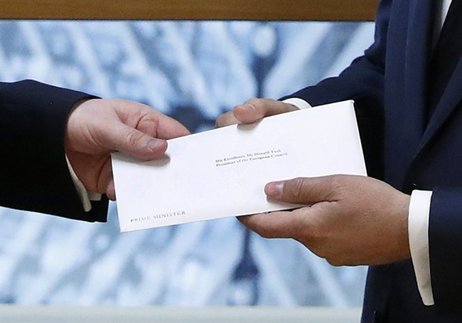 Britain's permanent representative to the European Union Tim Barrow, left, hand delivers British Prime Minister Theresa May's Brexit letter in notice of the UK's intention to leave the bloc under Article 50 of the EU's Lisbon Treaty to EU Council President Donald Tusk, in Brussels, Belgium, Wednesday, March 29, 2017. Barrow hand-delivered the letter signed by Britain's Prime Minister Theresa May that will formally trigger the beginning of Britain's exit from the European Union. (Yves Herman/Pool Photo via AP).