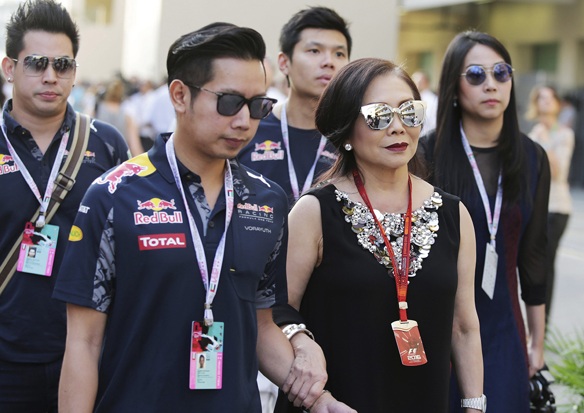 In this Nov. 26, 2016, photo provided by XPB Images, Vorayuth \”Boss\” Yoovidhya, second left, whose grandfather co-founded energy drink company Red Bull, walks with his mother Daranee, second right, at the Formula 1 Grand Prix in Abu Dhabi.