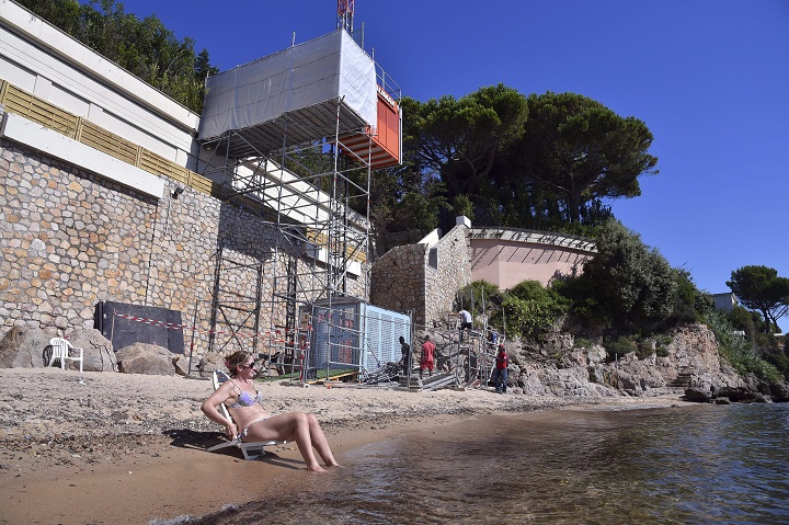 Workers dismantle a temporary elevator on a public beach below a mansion owned by the Saudi royal family in Golfe Juan Vallauris, southeastern France, Monday, Aug. 3, 2015.