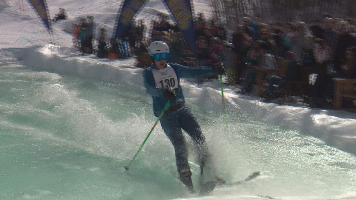 A skier glides across a pond at the 2017 Slush Cup.