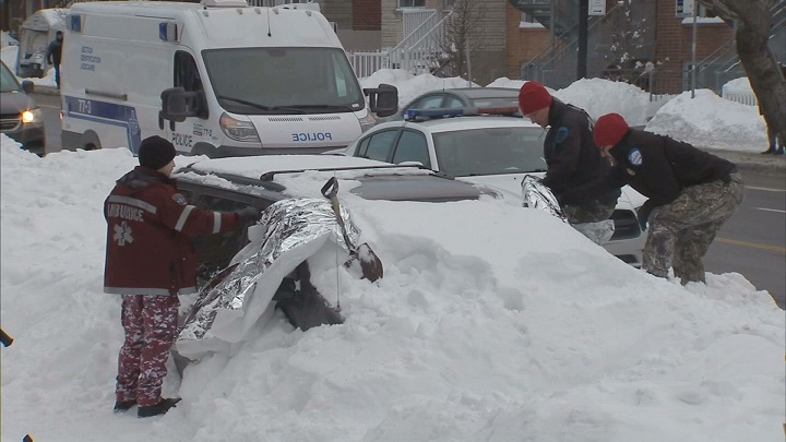 Police examine a snow covered car on St-Michel Boulevard, March 16, 2017.