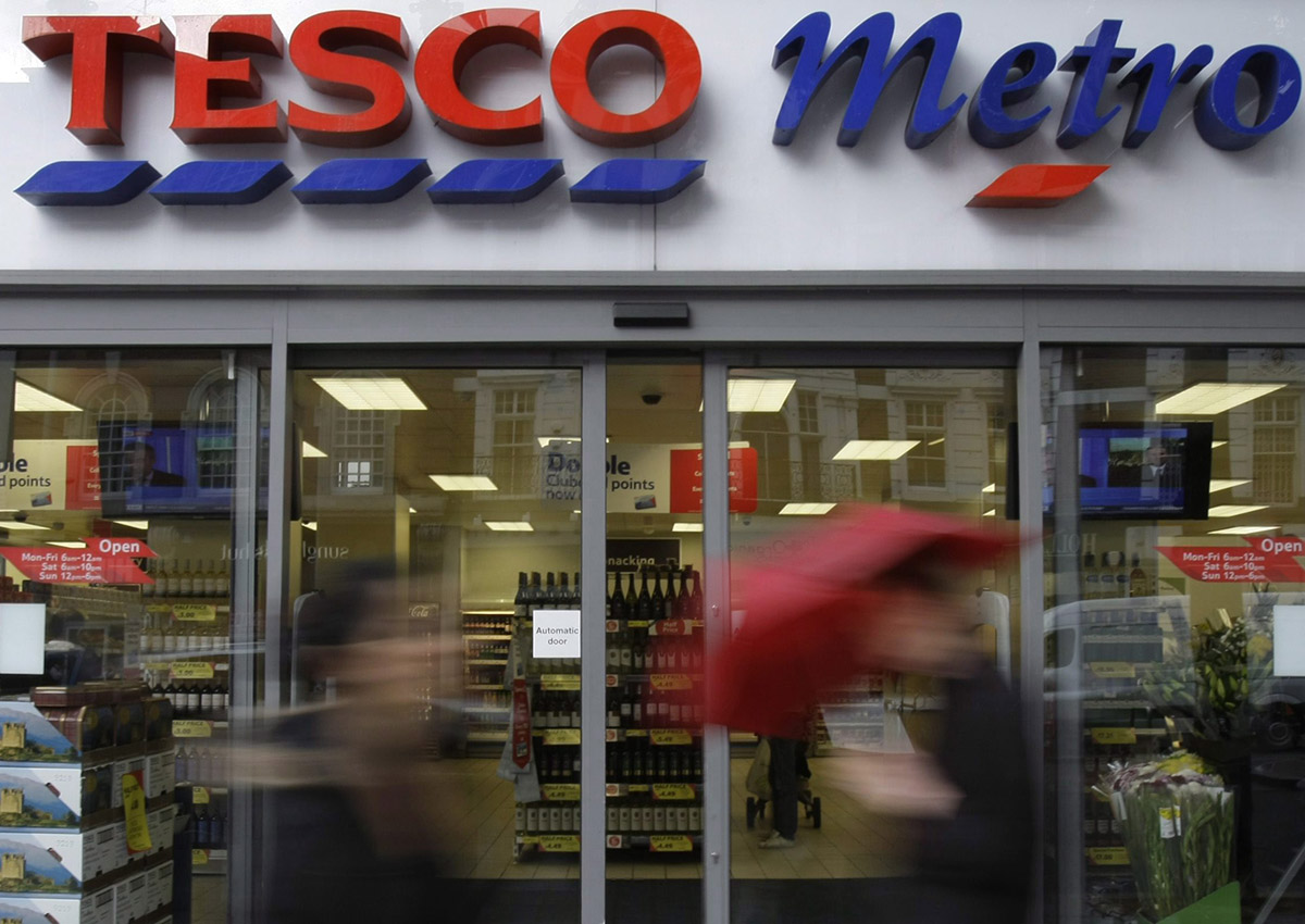  In this file photo dated Tuesday, Oct. 6, 2009, people pass by a branch of British retailer supermarket Tesco, in London. 