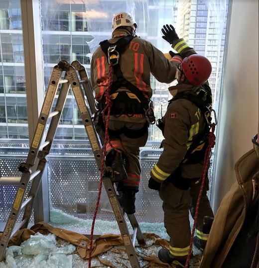 Firefighters break a window to rescue two workers stranded outside of a downtown Toronto office tower Thursday afternoon.