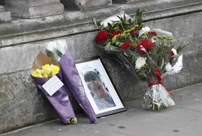 Flowers and a photo of killed police officer Keith Palmer on Whitehall near the Houses of Parliament in London, Thursday March 23, 2017.