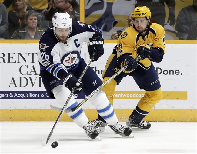 Winnipeg Jets captain Blake Wheeler (26) and Nashville Predators forward Filip Forsberg (9), battle for the puck.