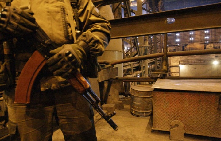 An armed man stands guard during the visit of head of the separatist self-proclaimed Donetsk People's Republic Alexander Zakharchenko (not pictured) to the Yuzovsky metallurgical plant in Donetsk, Ukraine, March 1, 2017. Rebels have cut thousands of the local residents' phone service.