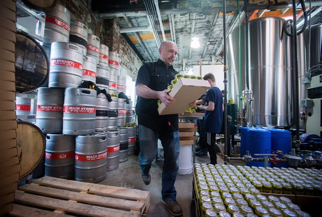 Main Street Brewing co-owner Nigel Pike stacks cans of beer during canning at the brewery in Vancouver, B.C., on Monday March 20, 2017.