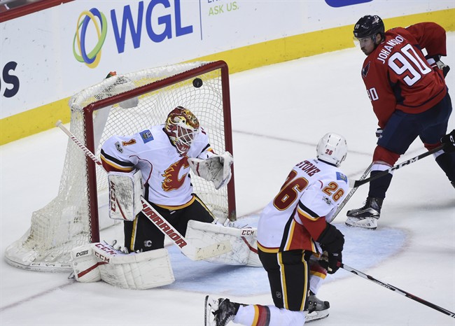 Calgary Flames goalie Brian Elliott (1) lets in a goal scored by Washington Capitals left wing Alex Ovechkin in front of left wing Marcus Johansson (90) and Calgary Flames defenseman Michael Stone (26) during the third period of an NHL hockey game, Tuesday, March 21, 2017, in Washington.