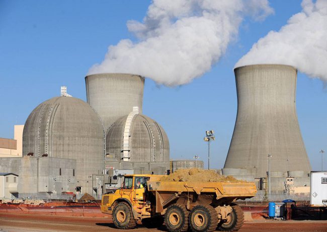 A file picture dated 17 February 2010 shows a construction vehicle passing by then two operational nuclear containment buildings and cooling towers at Georgia Power's Plant Vogtle nuclear power plant that use the Westinghouse AP1000 advanced pressurized water reactor technology.