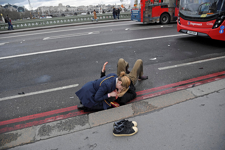  A woman assists an injured person after an incident on Westminster Bridge in London, Britain March 22, 2017.  