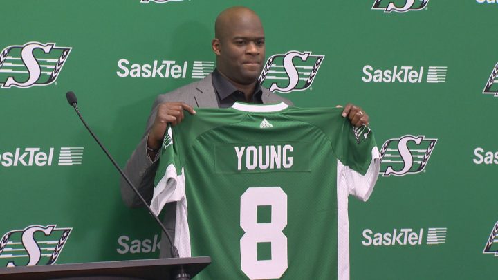 Saskatchewan Roughriders QB Vince Young is holding up a Riders jersey during his introductory press conference on March 9, 2017.