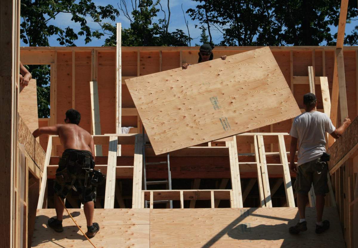 Construction workers work on a new home being built in Oakville, Ont., on Monday, July 23, 2012.