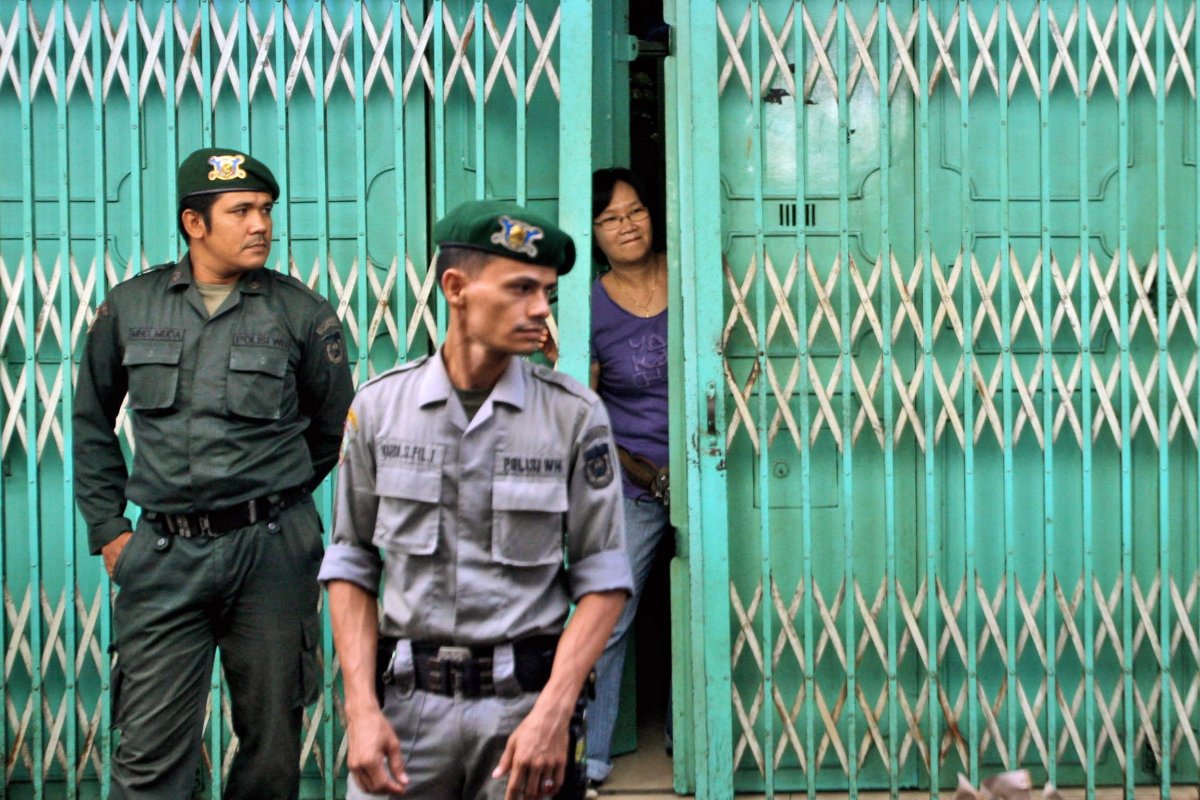 Sharia police officers stand guard outside a restaurant in Banda Aceh province on July 1, 2014.