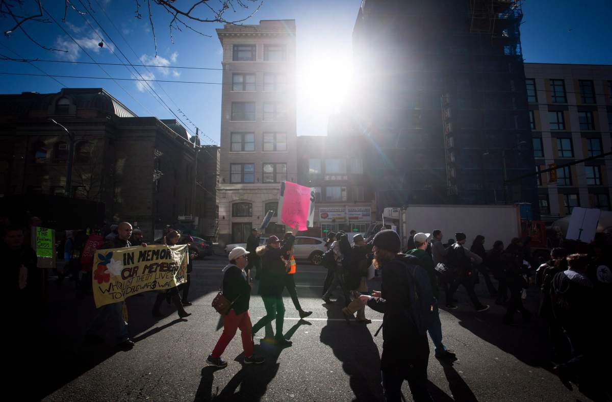 People march down East Hastings Street during the first National Day of Action to draw attention to the opioid overdose epidemic, in the Downtown Eastside of Vancouver, B.C., on Tuesday, February 21, 2017.