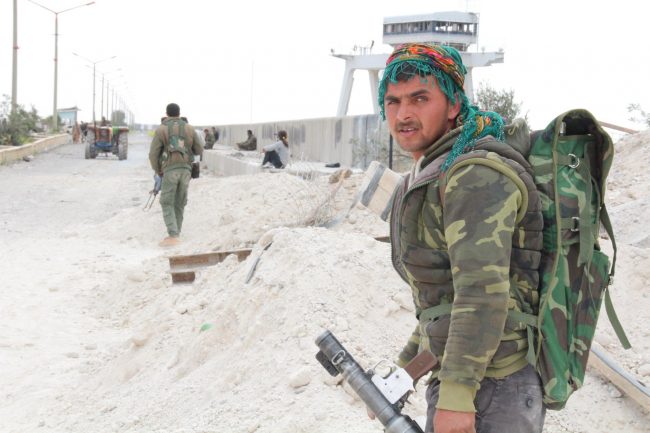 Members of the coalition forces take up positions nearby of the Euphrates dam where engineers opened one of the turbines on 30 March 2017, to ease the water pressure as the battles continue to control the entire dam so far. 