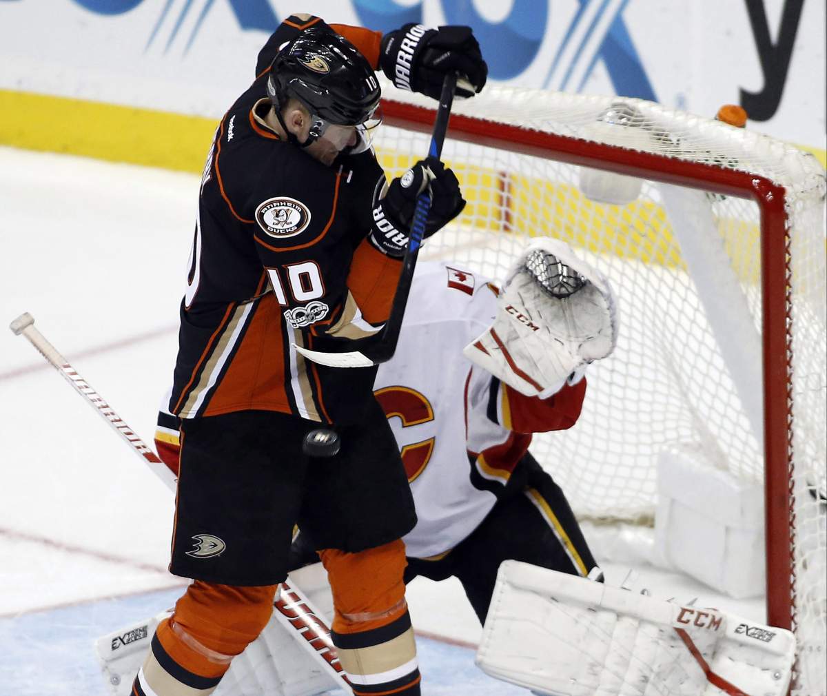 Anaheim Ducks right wing Corey Perry, left, redirects the puck against Calgary Flames goalie Brian Elliott (1) during the third period of an NHL hockey game in Anaheim, Calif., Tuesday, April 4, 2017. The Ducks won 3-1. (AP Photo/Alex Gallardo).