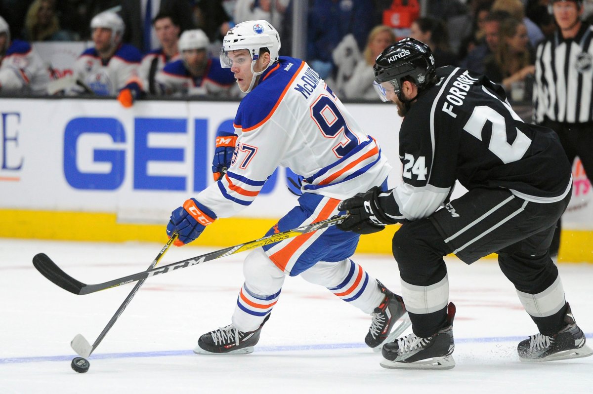 Edmonton Oilers center Connor McDavid (97) looks to pass as he is pressured by Los Angeles Kings defenseman Derek Forbort (24) in the third period of an NHL hockey game, Tuesday, April 4, 2017, in Los Angeles. The Kings won 6-4. 