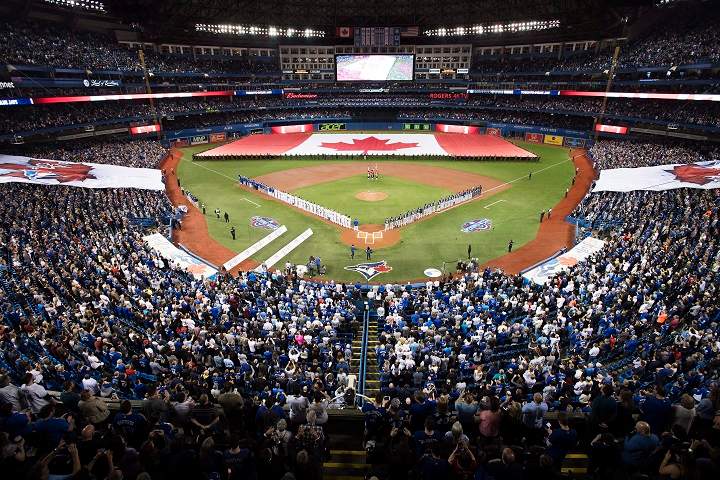 Toronto Blue Jays and Milwaukee Brewers players stand for the national anthems prior to interleague baseball action in Toronto, Tuesday, April 11, 2017.