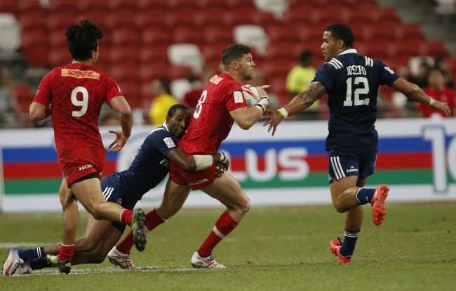 Justin Douglas of Canada is tackled by Perry Baker of the USA during the final match of the HSBC 7s World Rugby Series tournament held at the National Stadium in Singapore, 16 April 2017.  