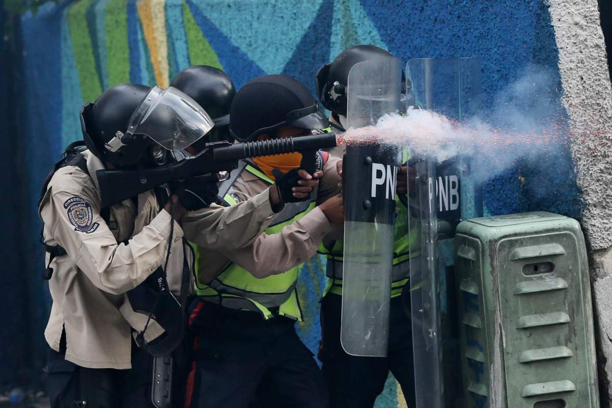 A police officer fires tear gas against anti-government protesters in Caracas, Venezuela, Wednesday, April 19, 2017. Tens of thousands of opponents of President Nicolas Maduro flooded the streets of Caracas in what’s been dubbed the “mother of all marches” against the embattled president. (AP Photo/Fernando Llano)
