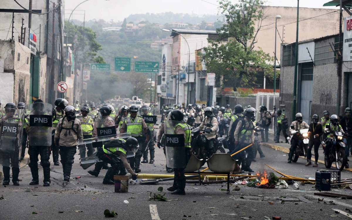 Police officers clear a barricade during anti-government protests in Caracas, Venezuela, Wednesday, April 19, 2017. Tens of thousands of opponents of President Nicolas Maduro flooded the streets of Caracas in what’s been dubbed the “mother of all marches” against the embattled president. (AP Photo/Fernando Llano)