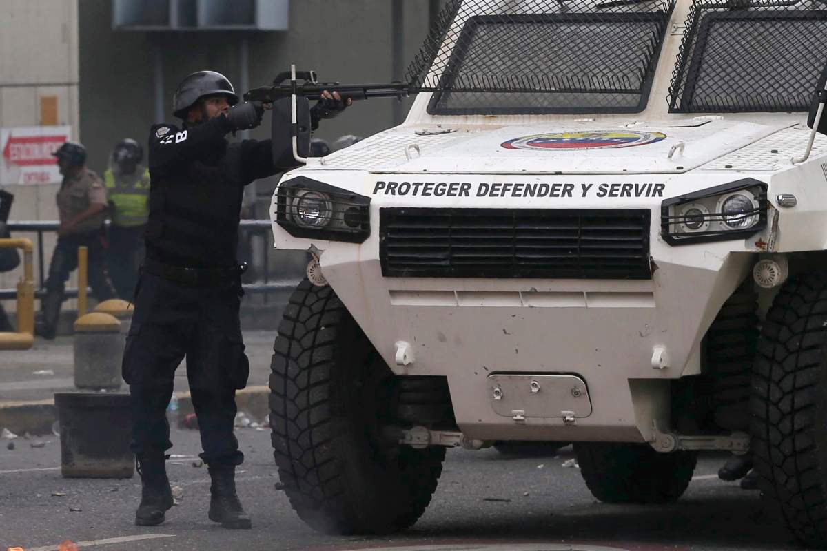 A police officer aims his weapon during anti-government protesters in Caracas, Venezuela, Wednesday, April 19, 2017. Tens of thousands of opponents of President Nicolas Maduro flooded the streets of Caracas in what’s been dubbed the “mother of all marches” against the embattled president. (AP Photo/Fernando Llano)