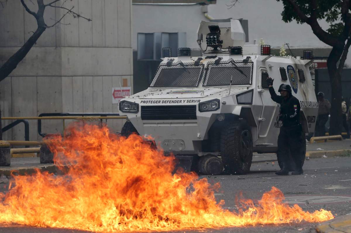 A police officer guides an armored vehicle during clashes with anti-government protesters in Caracas, Venezuela, Wednesday, April 19, 2017. Tens of thousands of opponents of President Nicolas Maduro flooded the streets of Caracas in what’s been dubbed the “mother of all marches” against the embattled president. (AP Photo/Fernando Llano)