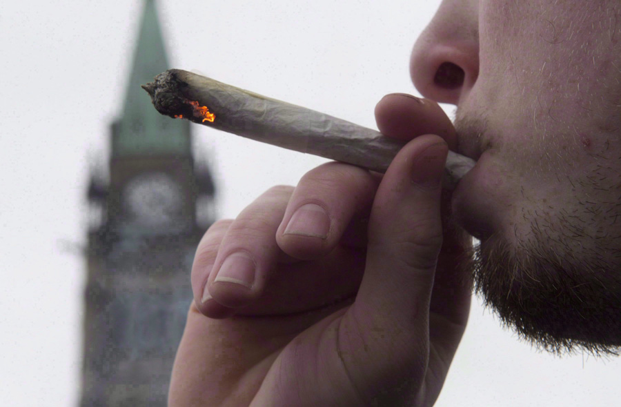 A man lights a marijuana joint as he participates in the 4/20 protest on Parliament Hill in Ottawa, April 20, 2015. Finance Minister Bill Morneau says the Liberal government has not decided how to tax marijuana, but is instead focused on making sure it stays out of the hands of children and criminals.THE CANADIAN PRESS/Adrian Wyld.