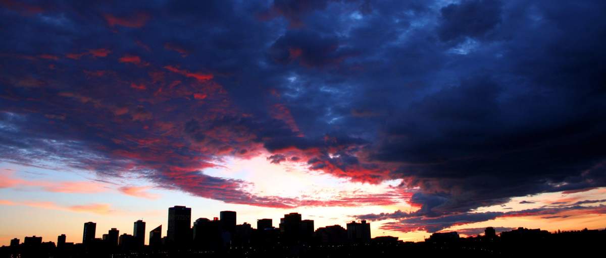 Downtown Edmonton is silhouetted by the setting sun as storm clouds move slowly over the city on a warm Saturday, July 2, 2005 evening.