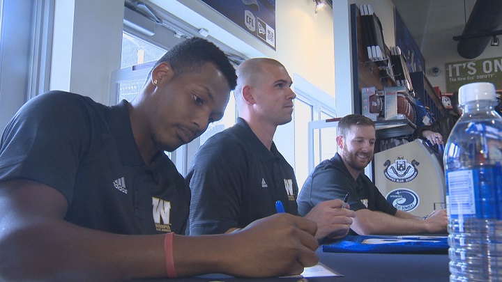 Winnipeg Blue Bombers quarterbacks Matt Nichols, Dan LeFevour and Dominique Davis sign autographs on Monday.