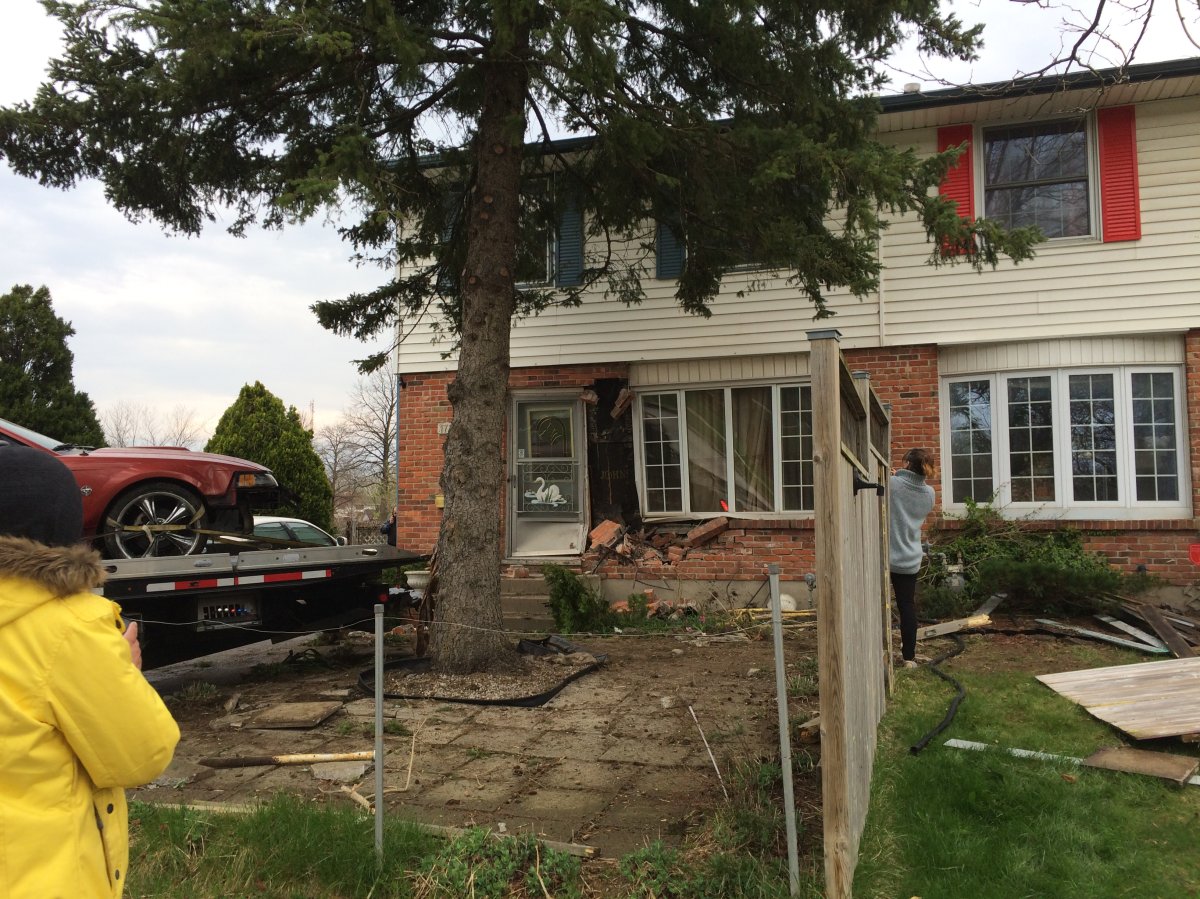 Neighbours assess the damage done to a home on Culver Drive after a vehicle struck the front portion on Wednesday, April 19, 2017.