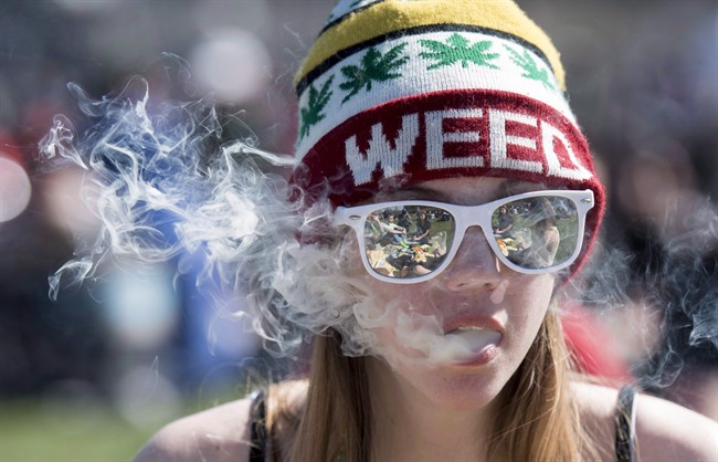 A woman exhales while smoking a joint during the annual 420 marijuana rally on Parliament hill on Wednesday, April 20, 2016 in Ottawa.