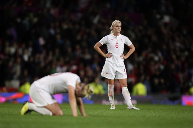 Canada's Kaylyn Kyle, right, reacts after her team's 4-3 loss to the United States in their semifinal women's soccer match at the 2012 London Summer Olympics, on Aug. 6, 2012 at Old Trafford Stadium in Manchester, England. Kyle announced on social media that she is retiring from international soccer.