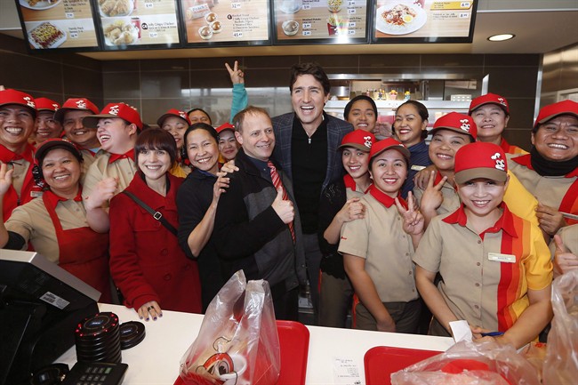 Prime Minister Justin Trudeau, centre, and Manitoba MLA Cindy Lamoureux, red coat, visits with staff at a local restaurant in Winnipeg in January. 