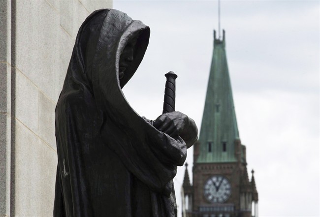 The Peace tower on Parliament Hill is seen behind the justice statue outside the Supreme Court of Canada in Ottawa, Monday June 6, 2016. The federal Liberals came to power promising sweeping reforms to the criminal justice system, but now the provinces are championing some ideas of their own as they focus on cutting backlogs in the courts. THE CANADIAN PRESS/Adrian Wyld.