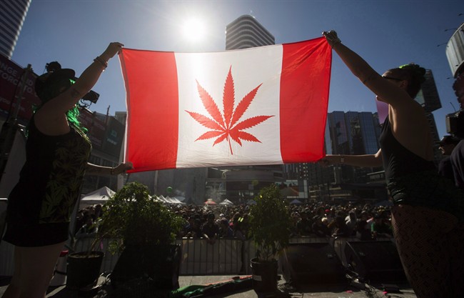 Two people hold a modified design of the Canadian flag with a marijuana leaf in place of the maple leaf during the “420 Toronto” rally in Toronto, April 20, 2016.