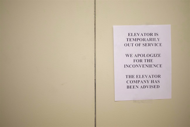 A sign is taped to a door of an elevator in a downtown Toronto office building on Wednesday, July 13, 2016. A retiree who says he hurt his leg after tumbling from a malfunctioning elevator in his downtown condominium is suing one of the world's largest elevator companies for negligence.