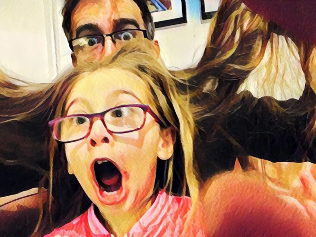 This father consults online tutorials to learn how to style his daughter's hair in a variety of creative ways. 