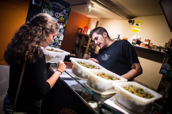 A staff member recommends different strains of marijuana to a member of a cannabis club in Barcelona, Spain, Aug. 22, 2014.