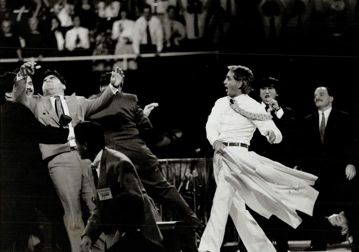 Benny Hinn: At left; and above; during Maple Leaf Gardens performance where he waved his coat about; proclaiming people cured of their ailments. (Photo by)
