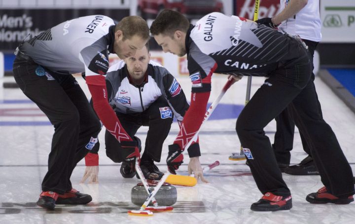 Canada skip Brad Gushue makes a shot as lead, Geoff Walker and second, Brett Gallant sweep during the 15th draw against Italy at the Men's World Curling Championships in Edmonton, Thursday, April 6, 2017. 
