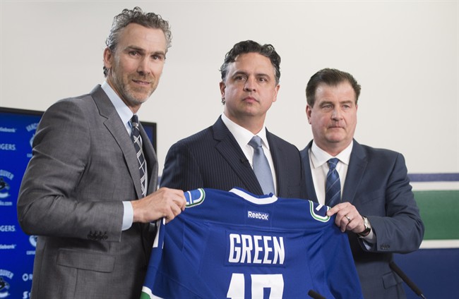 Former Vancouver Canucks president Trevor Linden, left, and general manager Jim Benning, right, introduce the Canucks new head coach Travis Green during a news conference in Vancouver, B.C. Wednesday, April, 26, 2017.