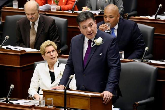 Premier Kathleen Wynne, left, looks on as Ontario Finance Minister Charles Sousa delivers the 2017 Ontario budget at Queen's Park in Toronto on Thursday, April 27, 2017. 