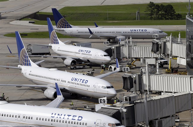 In this July 8, 2015, file photo, United Airlines planes are parked at their gates as another plane, top, taxis past them at George Bush Intercontinental Airport in Houston.